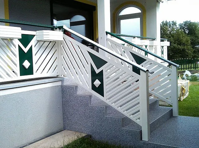 Ein weißes und grünes Geländer auf einer Veranda.