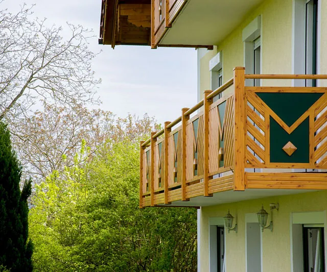 Ein weißes Gebäude mit einem grünen Balkon.