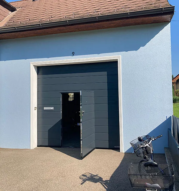 Ein Fahrrad steht vor einem Garagentor geparkt.