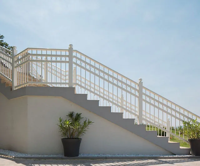 Eine weiße Geländer mit einem Blumenkasten auf der Seite.