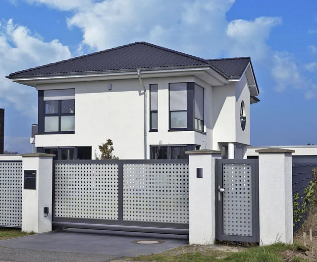 Modernes Haus mit einer Katze, die gemächlich am Zaun läuft.