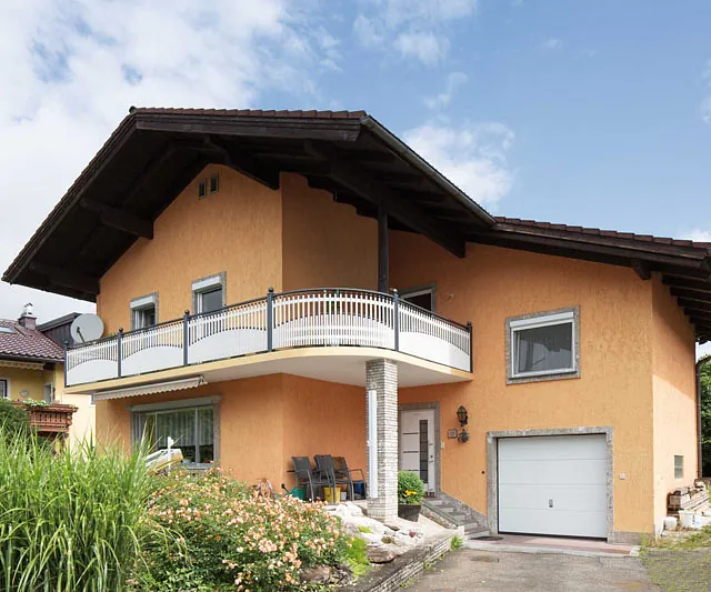 Ein imposantes Haus mit einem Balkon, der die Fassade des Gebäudes elegant ergänzt.
