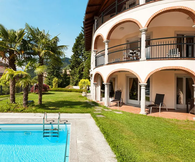 Ein großzügiger Pool im Außenbereich, umgeben von Grünflächen, bietet eine einladende Atmosphäre zum Entspannen.
