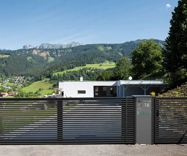  Zeitgenössisches Wohnhaus mit einem Eingangstor und einer breiten Auffahrt.