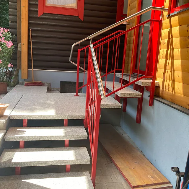 Rote Geländer an einer Treppe, die den Auf- und Abstieg sichern.