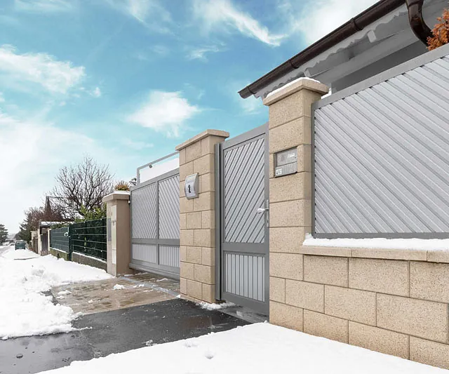 Ein Zaun und eine Einfahrt, beide vollständig mit Schnee überzogen.