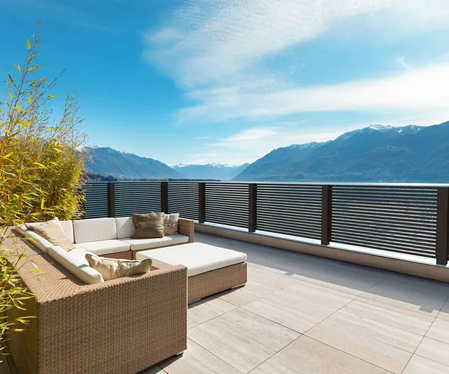 Balkon mit Holzfußboden und einem einladenden Patio-Bereich.