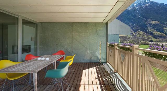 Ein Balkon mit Möbeln, der eine weite Sicht auf eine majestätische Berglandschaft ermöglicht.