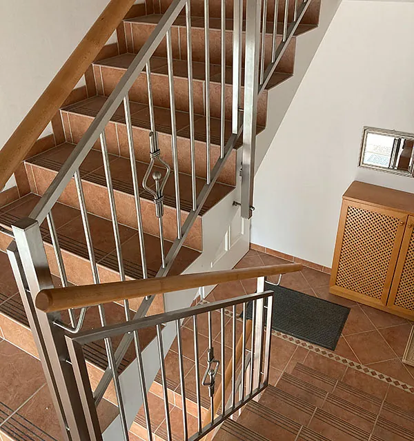 Eine Treppe mit einem Metallgeländer und einem Holzhandlauf.