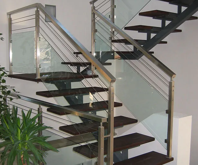 Glasgeländer mit Metallhandläufen an einer Treppe.