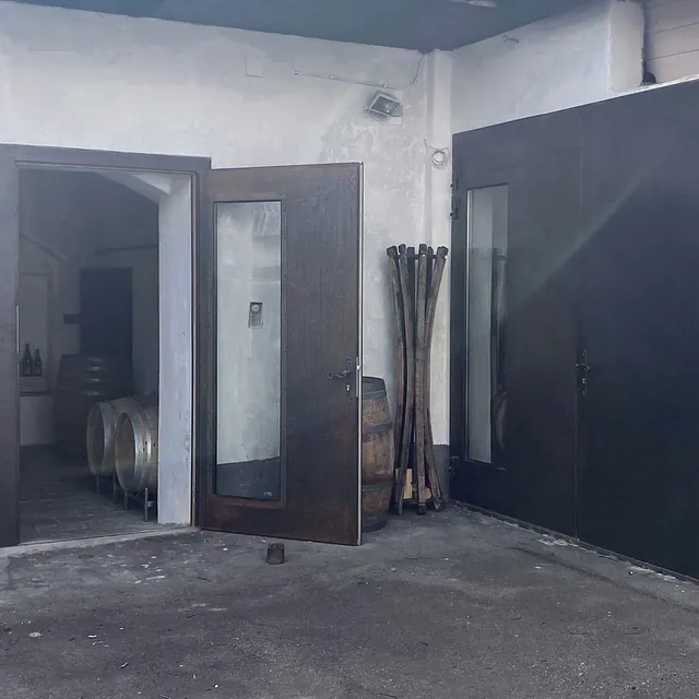 Innenansicht eines Raumes mit zwei Türen und einem Holzfass.