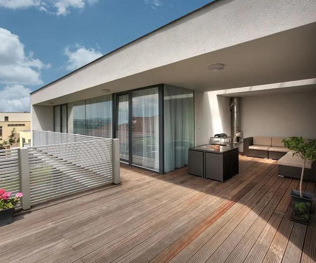 Ein Balkon mit Holzboden und einem gemütlichen Patio-Bereich.