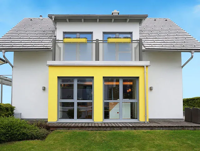 Ein modernes Gebäude, während eine Katze am Zaun entlanggeht.