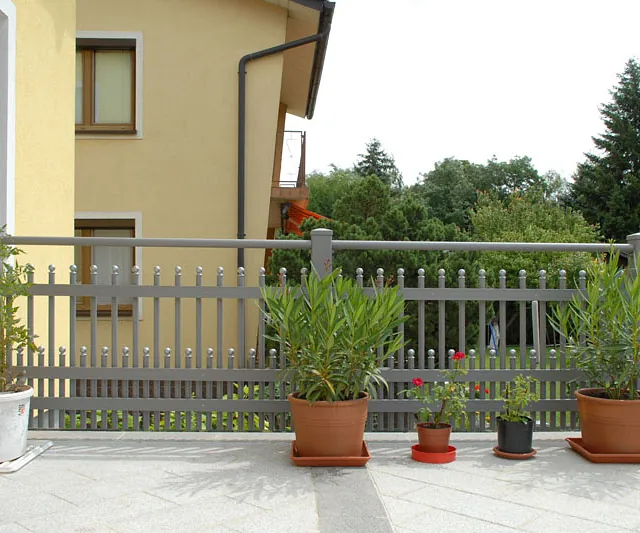  Eine gemütliche Terrasse, geschmückt mit mehreren Töpfen voller Pflanzen.