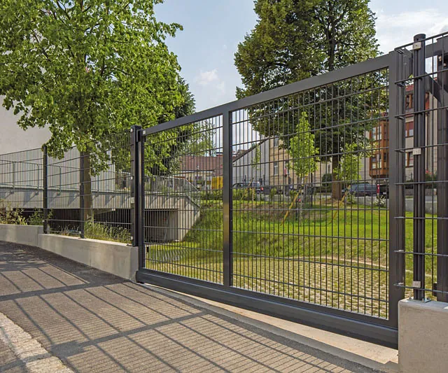 Ein Tor mit einem Zaun und einem Gehweg, der den Zugang zu einem Bereich markiert.